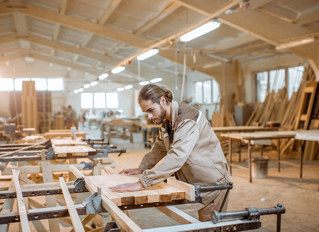 Carpenter Insurance - Man Working In His Woodshop on a Large Wood Project