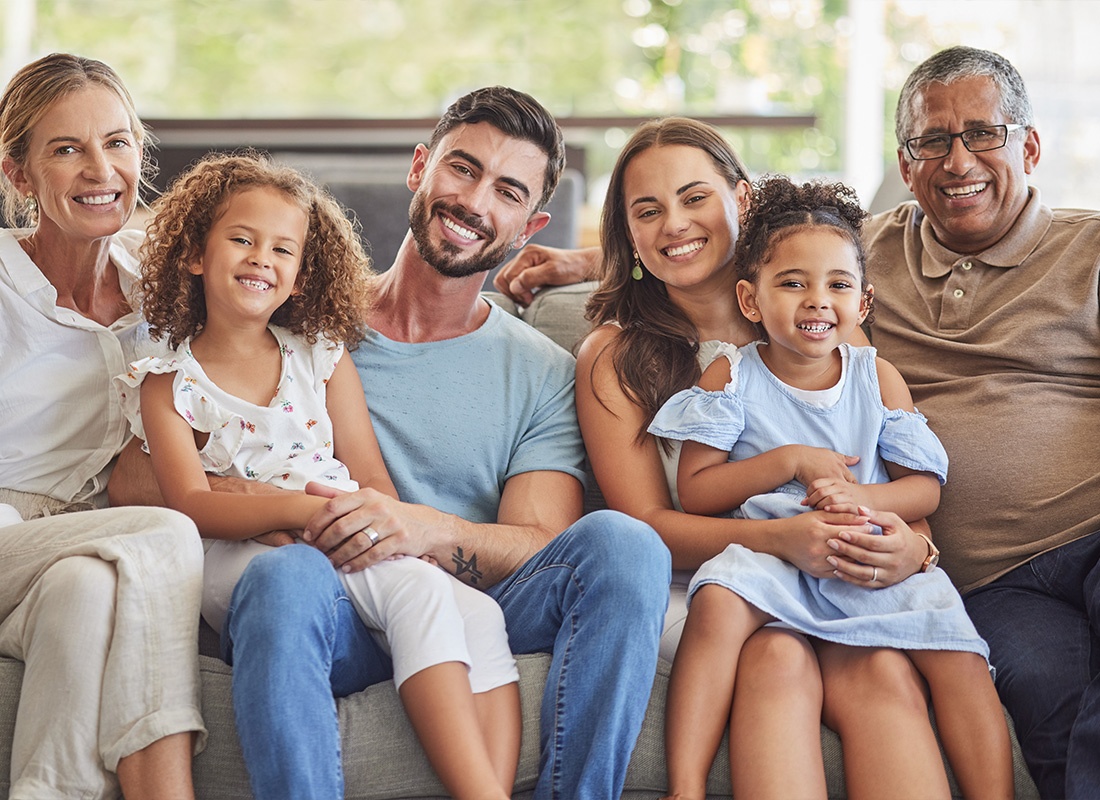 Personal Insurance - A Happy Family Gathered Together on a Couch in Their Living Room